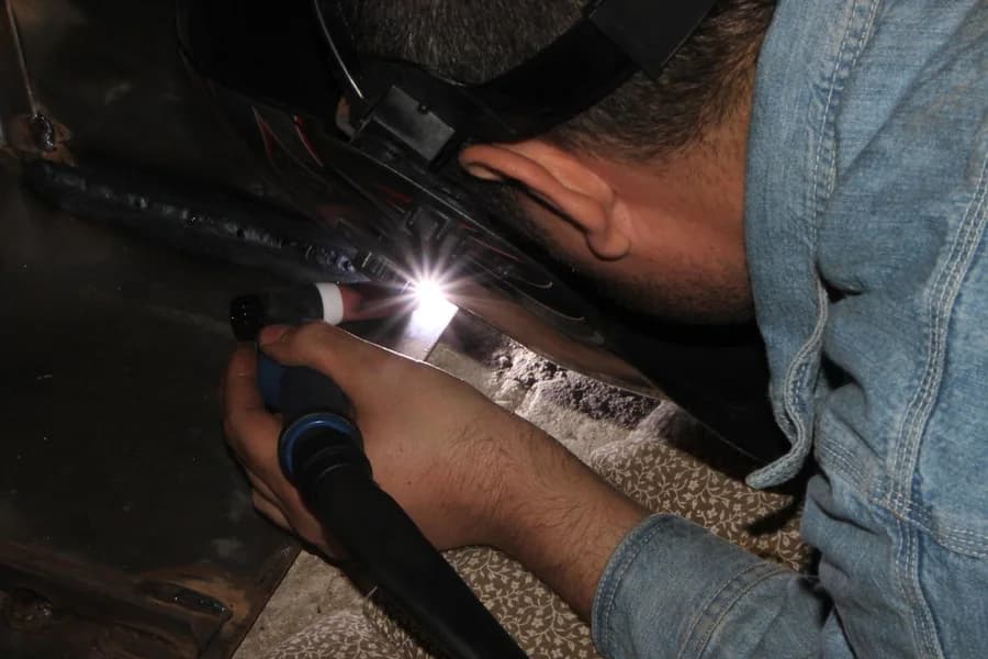 A welder joining metal with a TIG torch