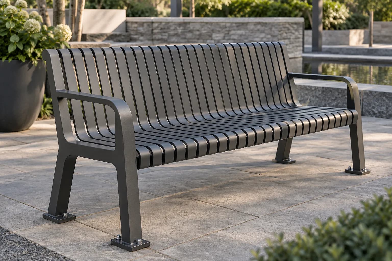 Graphite slatted metal bench with armrests and anchored feet