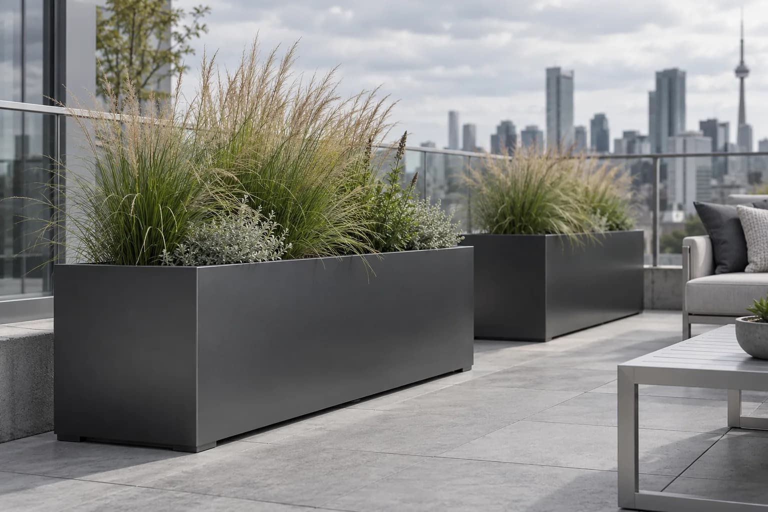 Rectangular graphite metal planters with ornamental grasses on a terrace