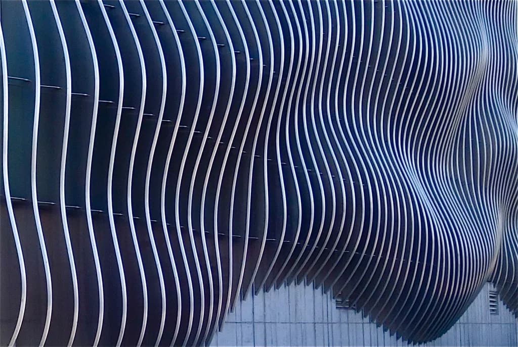 Formed metal panels with curved vertical profiles